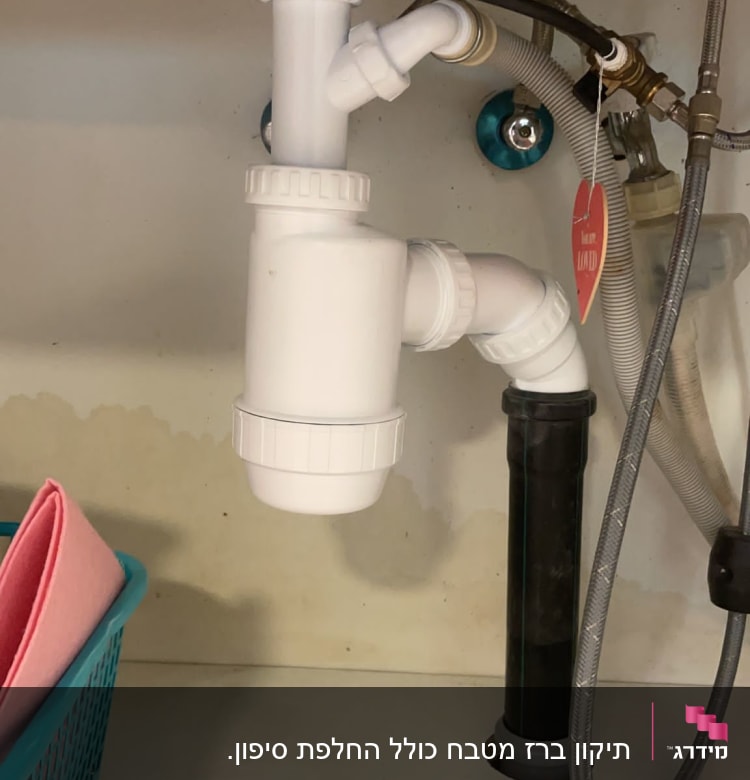 צנרת פלסטיק לבנה מתחת לכיור עם חיבורים
